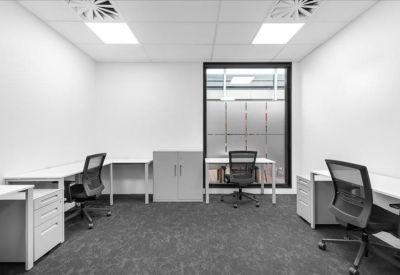 Private internal office with two desks and white storage cabinets.
