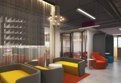 Casual lounge area with grey and yellow tub chairs and a red area rug.