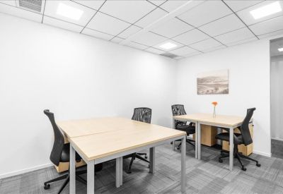 Bright four-person private office suite with minimalist wooden desks.