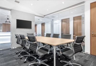Professional conference room with a large wood table and black executive chairs.