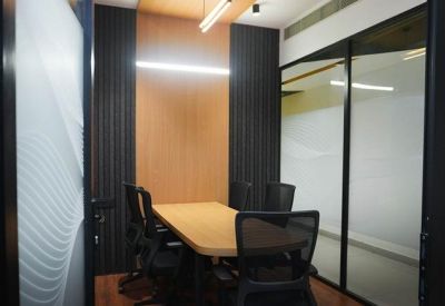 Small four-person meeting room with wooden table and textured glass partitions.