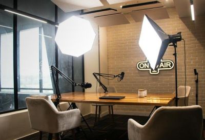 Professional podcast studio with microphones, softbox lighting, and an On Air sign.