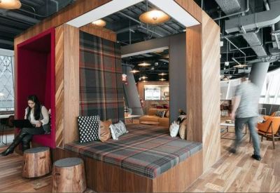Wood-paneled breakout area with a plaid-upholstered seating nook and industrial ceiling.