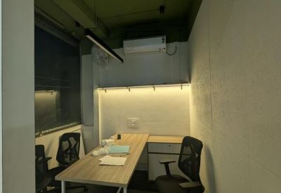 Private office suite featuring a wooden desk and ergonomic black chairs.