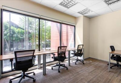 Bright coworking area with window-facing desks and natural light.