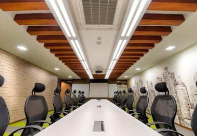 Spacious boardroom featuring a long white table, ergonomic black chairs, and a decorative wood-slat ceiling.