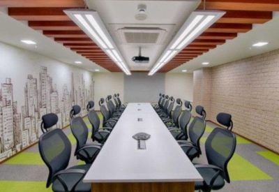 Spacious meeting room with a long white table, green carpet accents, and a city skyline mural.