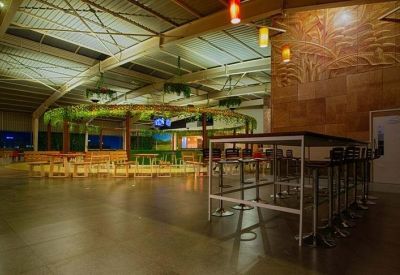 Large industrial-style cafeteria area with high tables, warm lighting, and decorative greenery.