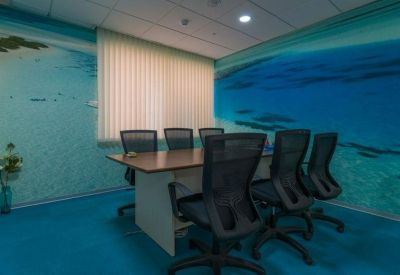 Small meeting room with ocean-themed wall murals and blue carpeting.