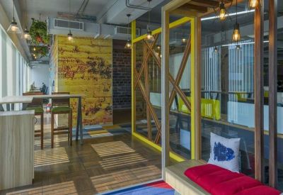 Bright breakout space featuring a wooden lattice partition and a yellow graphic feature wall.