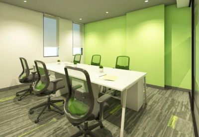 Small meeting room or private office featuring a white table and green mesh chairs.