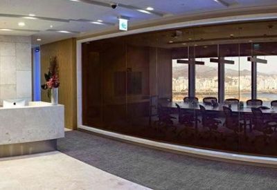 Professional reception area with a minimalist front desk and glass-walled meeting room.