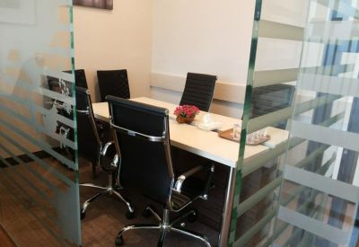 Small meeting room with a table and black chairs.