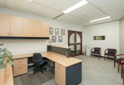 Office space with L-shaped desk and waiting area chairs.