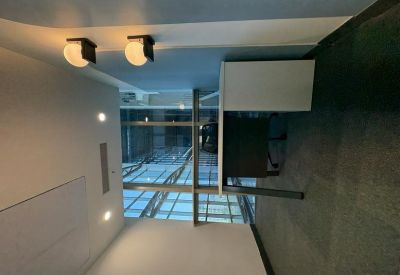 Private office workstation with warm wall-mounted globe lights and a glass partition.