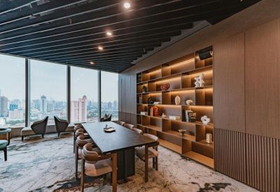 Modern boardroom featuring a dark wood table and built-in lit shelving with city views.