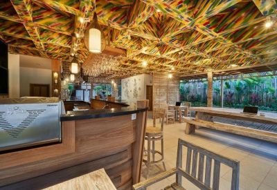 Spacious communal coworking area with a colorful painted timber ceiling and bar seating.