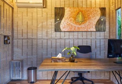 Front desk reception area with bamboo walls and a decorative gold leaf painting.