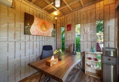 Private office with a live-edge wooden desk and bamboo-textured walls.