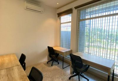 Shared office space with natural light and multiple workstations.