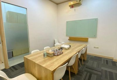 Spacious boardroom featuring a large wooden table and white designer chairs.