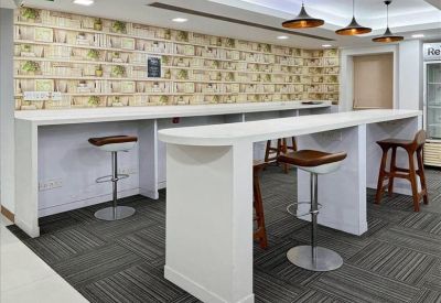 Communal break area with high-top white counters and patterned wall art.