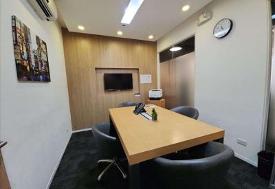 Bright reception area featuring a white desk with under-lighting and a warm wood-paneled feature wall.