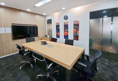 Symmetrical open-plan office with white desks, privacy screens, and hanging dome lights.