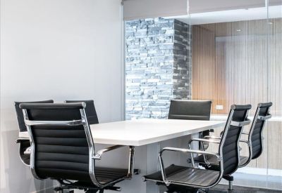 Professional meeting room with black leather chairs and a glass partition.