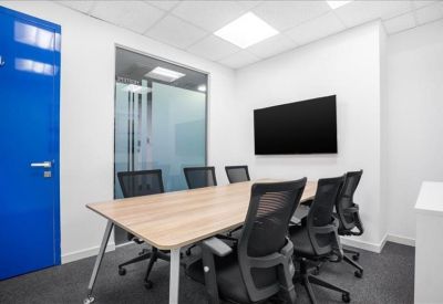 Modern meeting room featuring a wooden table, wall-mounted screen, and blue accent door.