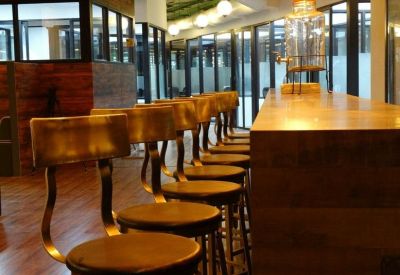 Café seating area with wooden bar counter and stylish industrial-style stools.