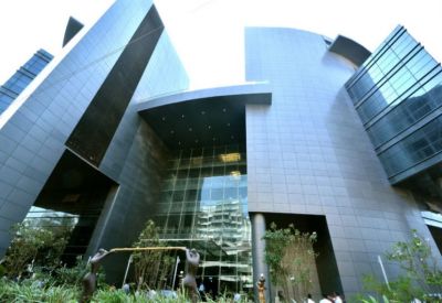 Low-angle view of the modern, geometric glass and stone facade of Kaledonia.