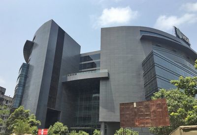 Wide exterior shot of the commercial building with curved glass wings and a central entrance canopy.