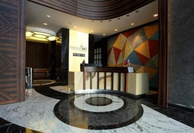 Spacious reception lobby featuring a geometric patterned floor and a colourful mosaic feature wall.