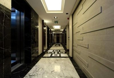 Modern corridor with polished marble flooring and a decorative textured feature wall.
