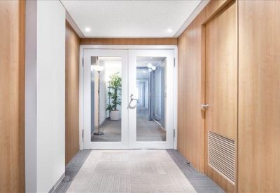 Entrance lobby with wooden paneling and double glass doors.