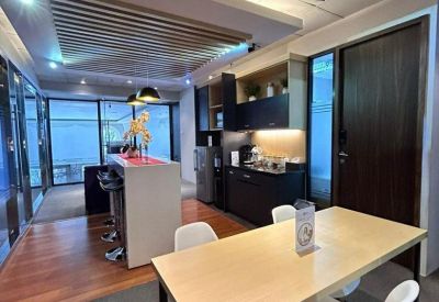 Communal kitchen with dining table and wooden flooring.