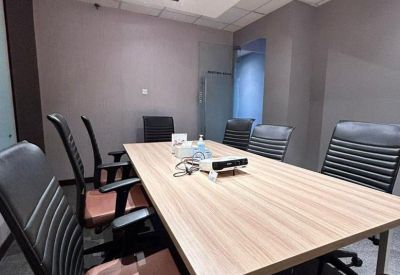 Conference room with long table and black chairs.