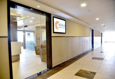 Glass entrance door to a professional suite with wall-mounted digital signage.