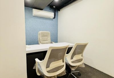 Private office featuring a white desk, two mesh chairs, and a blue accent wall.