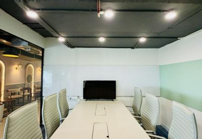 Bright conference room with a long white table and white ergonomic chairs.