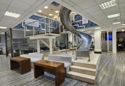 Modern lounge area featuring wooden desks and a playful indoor slide.
