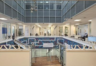 Bright multi-level atrium with glass railings and decorative wall patterns.