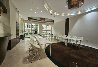 Elegant communal lounge or break area with white chairs and warm overhead lighting.