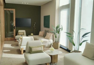 Lounge area with cream-colored armchairs, a marble coffee table, and soft natural light.