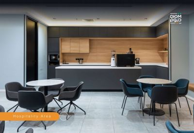 Hospitality area featuring a dark cabinetry kitchenette and modern dining tables.