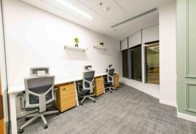 Bright four-person private office with ergonomic grey chairs and wooden pedestals.