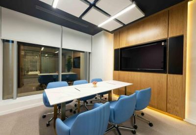 Glazed internal corridor showing private office suites with glass walls and wooden doors.