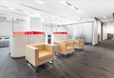 Lounge area with tan box armchairs and modern white dividers.