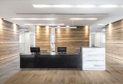 Elegant reception area with a black marble desk and textured wood walls.